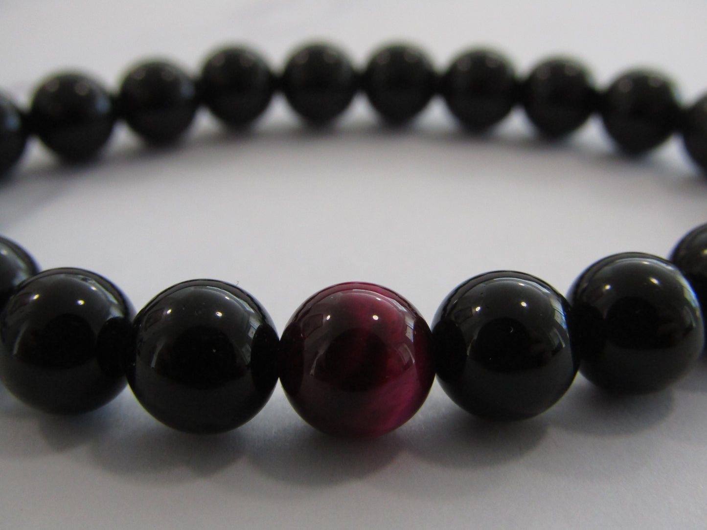 Obsidian bracelet with 1 x magenta Tigers Eye (dyed) bead