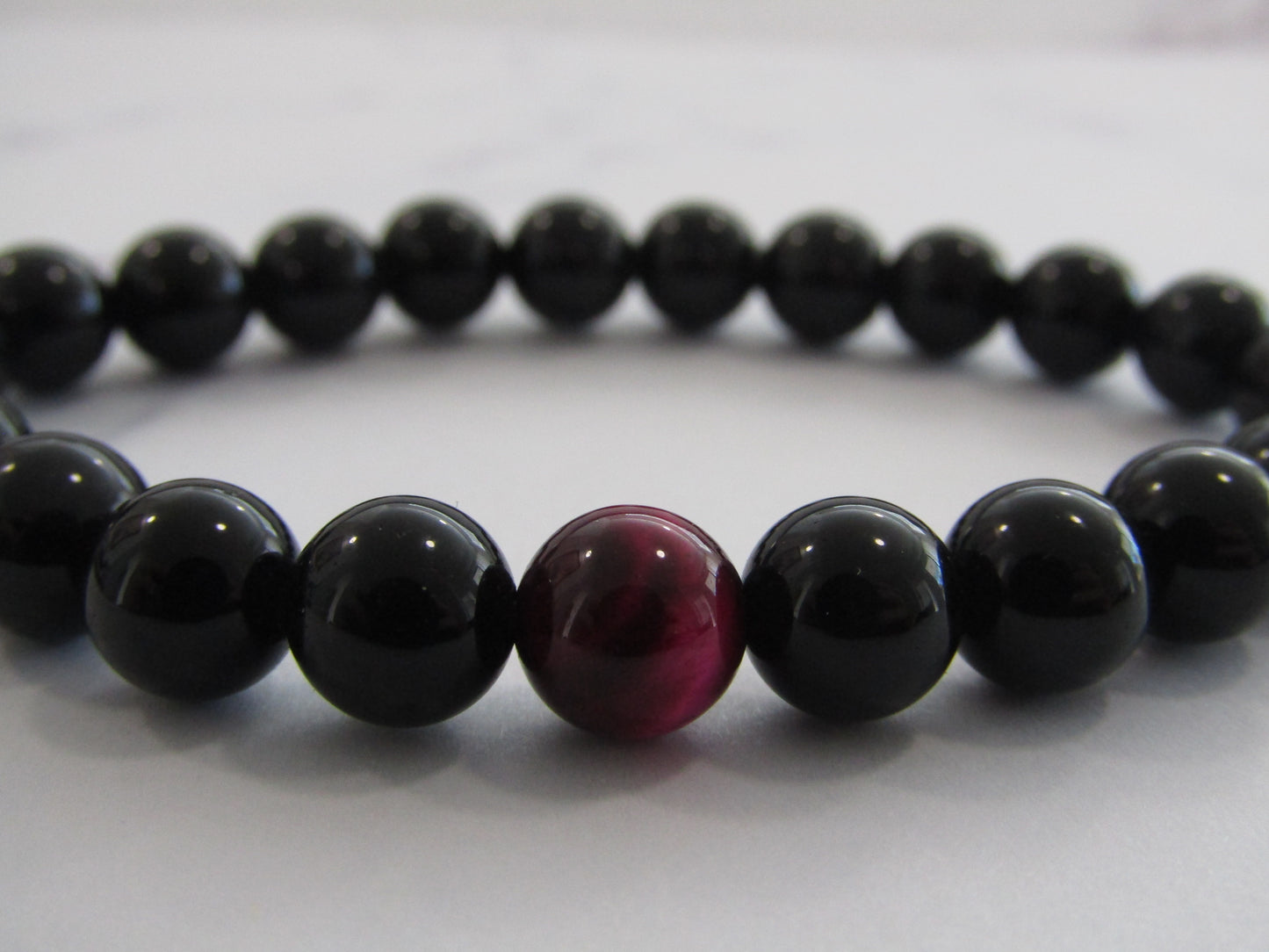 Obsidian bracelet with 1 x magenta Tigers Eye (dyed) bead